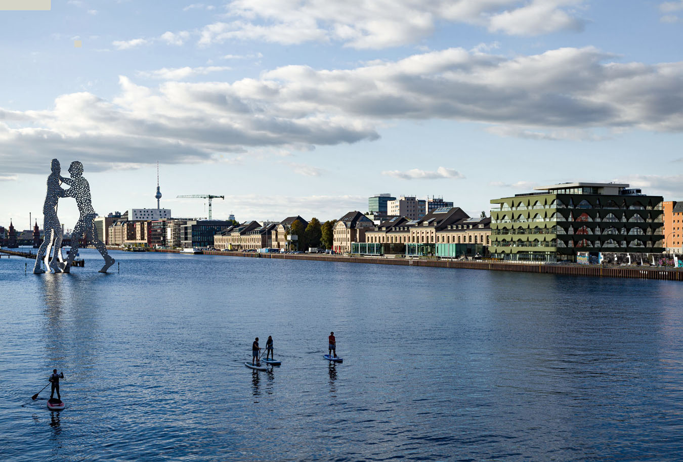 Spree, Modezentrum und Skulptur am Abend, im Hintergrund Mister der Fernsehturm und die Oberbaumbrücke zu sehen.