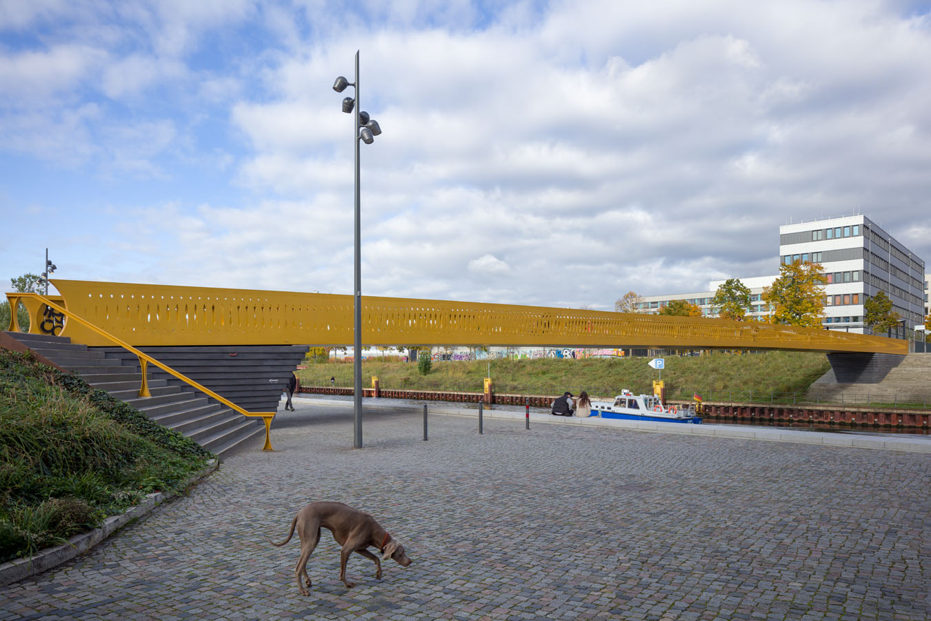 Die neue Brücke in der Europacity – der von ACME entworfene Golda-Meir-Steg. Ein Hund bleibt kurz stehen, während hinter ihm ein neues Stück Stadt entstanden ist.