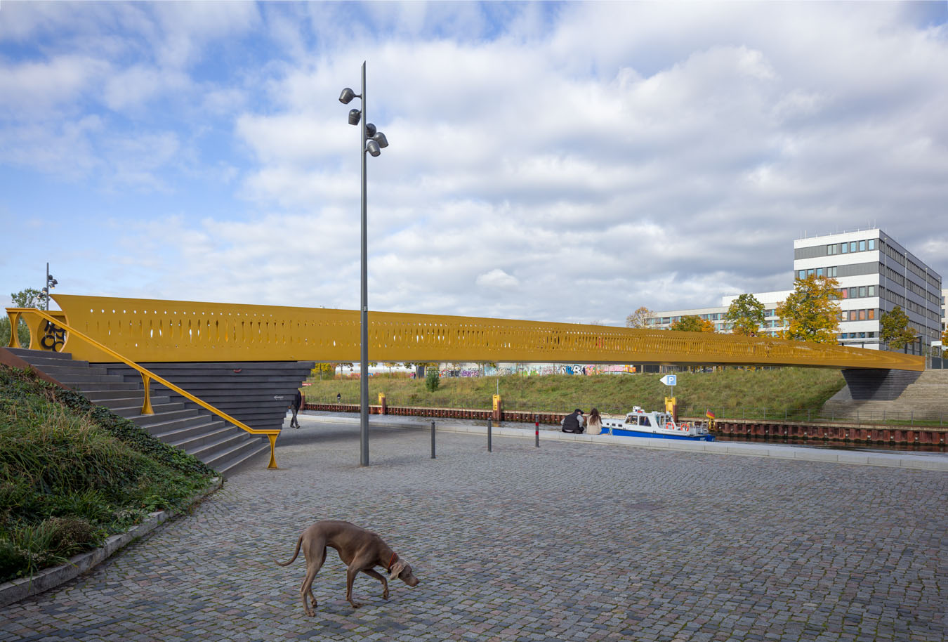 Die neue Brücke in der Europacity – der von ACME entworfene Golda-Meir-Steg. Ein Hund bleibt kurz stehen, während hinter ihm ein neues Stück Stadt entstanden ist.