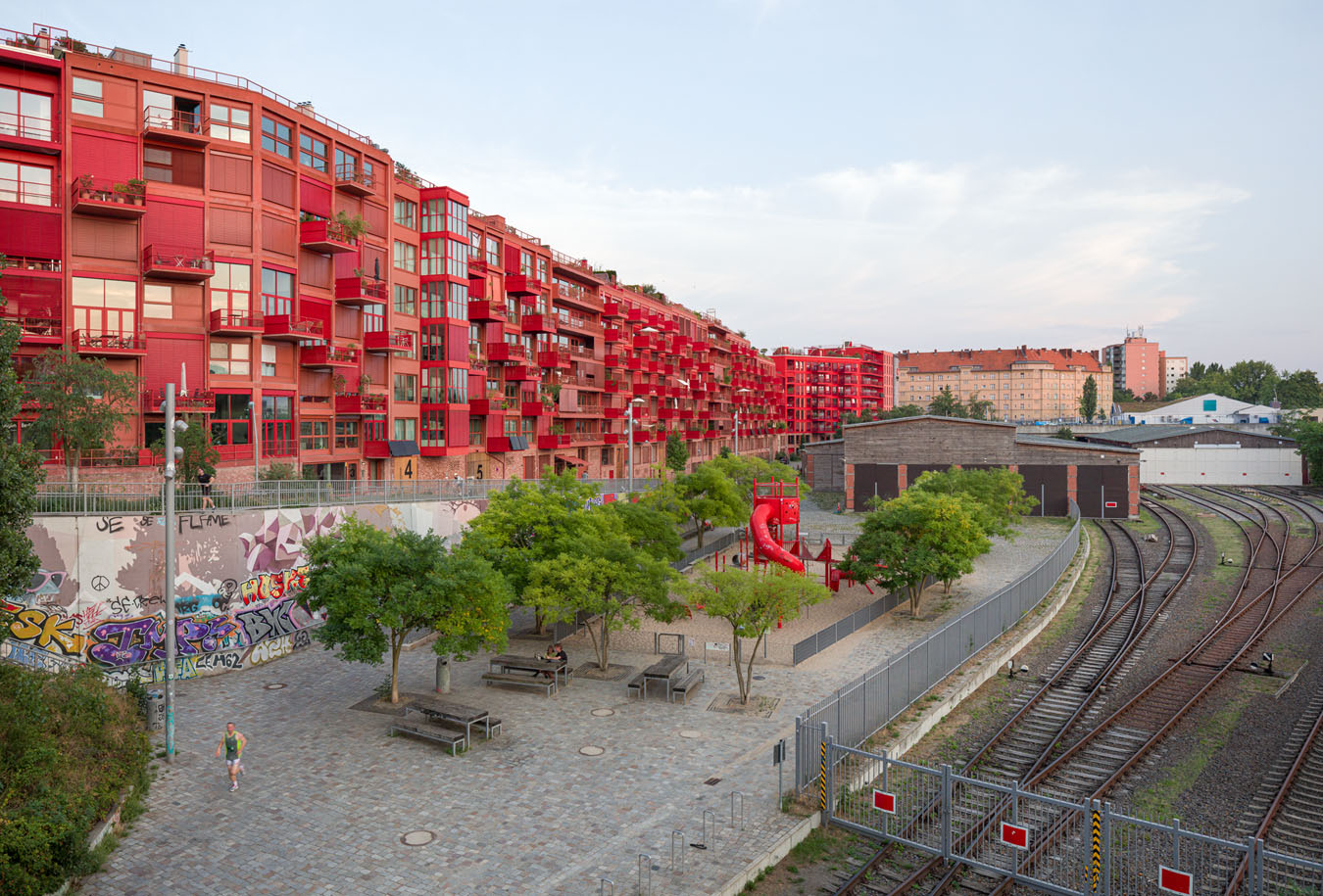 Am Lokdepot, Berlin – Blick über das ehemalige Bahngelände auf das neue Stadtquartier mit Wohngebäuden, Bahntrassen und historischen Industriehallen.