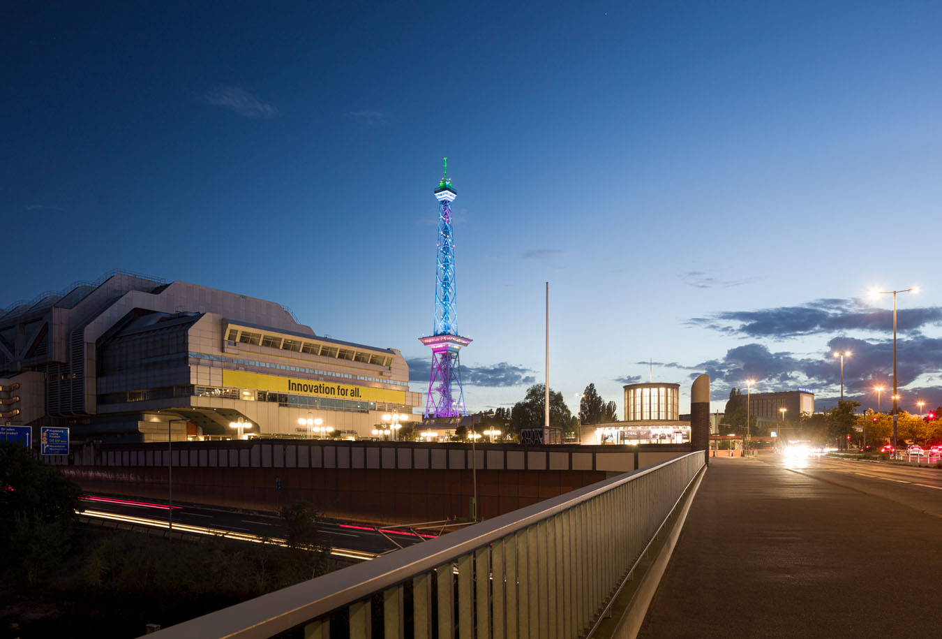 Illuminierter Berliner Funkturm bei Nacht mit Verkehrsinfrastruktur am Messegelände in Berlin.